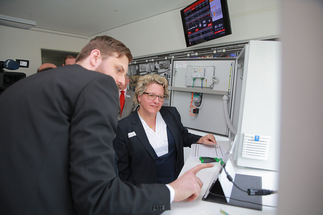 Foto (Michael Adamski): Matthias Greinert (Wissenschaftler am Fraunhofer IEM) zeigt NRW-Wissenschaftsministerin Svenja Schulze eine digitale Montageanleitung für einen Schaltschrank.